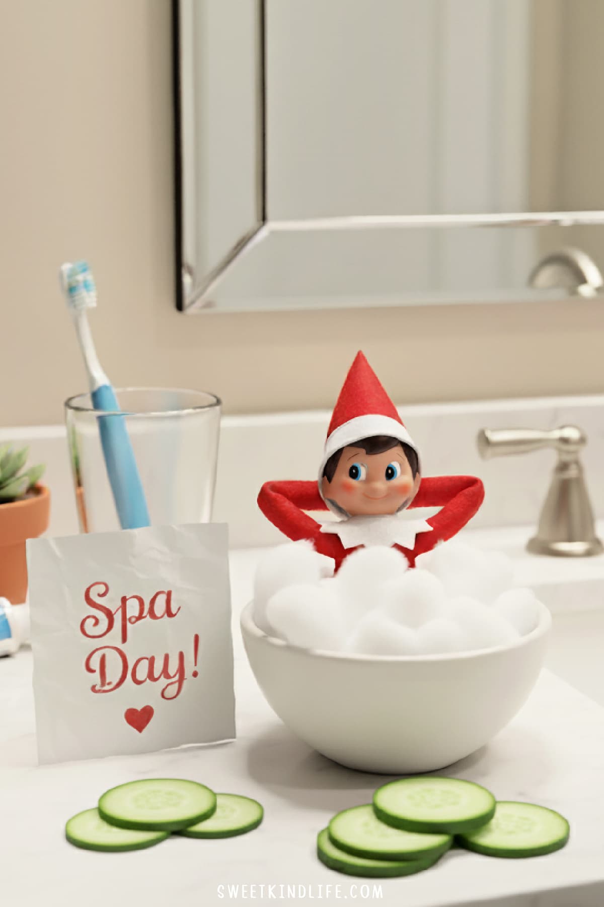 a girl elf on the shelf in a bowl with cotton balls with a spa day sign in the bathroom